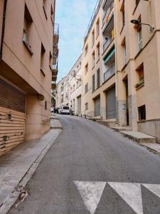 an empty street in an alley between buildings at Newly renovated cozy apartment on a hill in Arenys de Mar