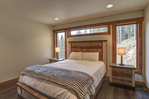 a bedroom with a bed and two lamps and a window at Wildercreek Cabin in Lead