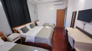 ein Hotelzimmer mit 2 Betten und einem Flachbild-TV in der Unterkunft KayDee GuestHouse in Rom