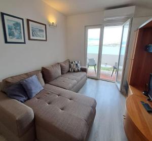 a living room with a couch and a large window at City Pag Apartment in Pag