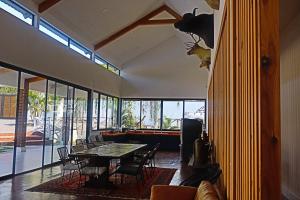 una sala da pranzo con tavolo, sedie e finestre di Villa Casa Encantadora a Retalhuleu