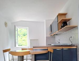 a kitchen with a counter with chairs and a sink at City Pag Apartment in Pag