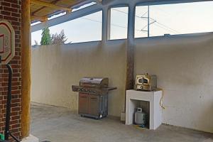 an outdoor kitchen with a stove and a microwave at Villa Casa Encantadora in Retalhuleu