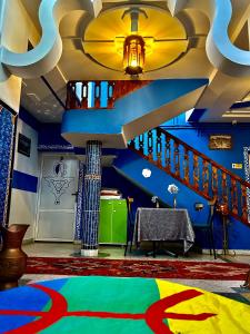 a living room with a colorful carpet and stairs at Hôtel Riad Atlas Dades in Boumalne Dades