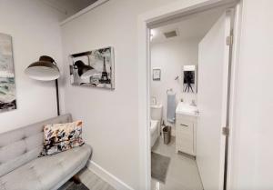 a white bathroom with a couch and a sink at Studio in the heart of downtown in Ottawa