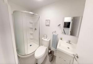 a white bathroom with a toilet and a sink at Studio in the heart of downtown in Ottawa