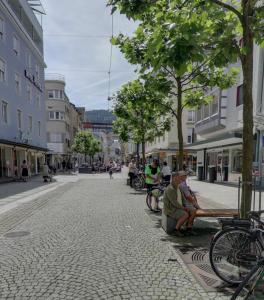 two people sitting on a bench on a city street at OH 5 in Bregenz