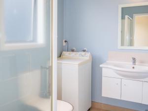 ein Badezimmer mit einem weißen WC und einem Waschbecken in der Unterkunft Waihi Wonder - Waihi Holiday Home in Waihi Beach
