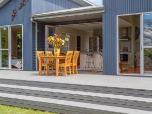 a patio with a table and chairs on a house at Waihi Wonder - Waihi Holiday Home in Waihi Beach +9 photos
