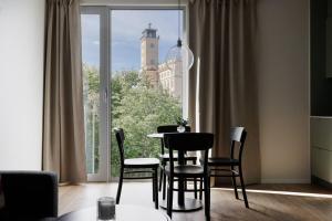 a dining room with a table and chairs in front of a window at Brand new Studios Amidst Ancient Ruins Oasis in Stockholm