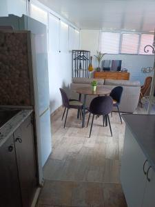 cocina y sala de estar con mesa y sillas en La casa de huespedes, en Puebla de Vallbona
