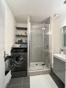 ein Bad mit einer Waschmaschine und einer Dusche in der Unterkunft 2P calme 70m du métro M4 Barbara - 4 pers maximum in Montrouge
