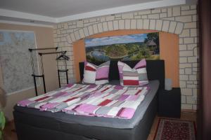 ein Schlafzimmer mit einem großen Bett mit Ziegelwand in der Unterkunft Marktstübchen an der schönen Loreley in Bornich
