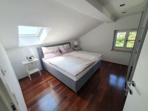 Schlafzimmer mit einem Bett und Holzboden in der Unterkunft Moderne Ferienwohnung Bestlage in Mattsee Salzburg Salzburger Seenland Urlaub am See in Mattsee