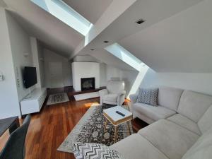 ein Wohnzimmer mit einem Sofa und einem TV in der Unterkunft Moderne Ferienwohnung Bestlage in Mattsee Salzburg Salzburger Seenland Urlaub am See in Mattsee