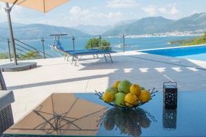 a bowl of fruit on a table next to a pool at Villa Vista Azzurra in Tivat