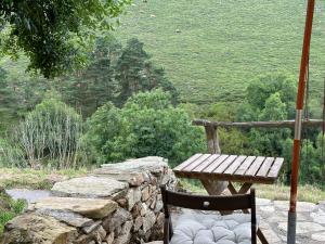 提內奧的住宿－Ca Manín，一张木桌和椅子,坐在石墙旁
