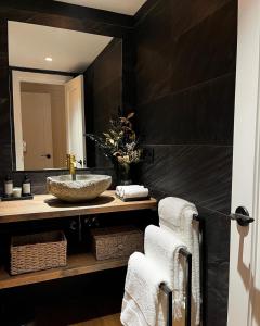 uma casa de banho com lavatório, espelho e toalhas em Apartamento LOS CORZOS - LA PINILLA em Cerezo de Arriba