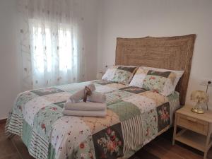 ein Schlafzimmer mit einem Bett mit einer Puppe drauf in der Unterkunft Alojamiento Turístico La Cantuérgana in San Martín de Montalbán