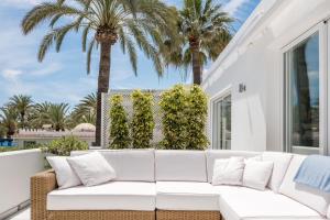 ein weißes Sofa auf einer Veranda mit Palmen in der Unterkunft OASIS Beachfront Golden Mile in Marbella + 18 Fotos