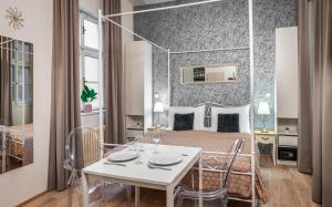 プラハにある7 Tales Apartments by Adrezのベッドルーム1室(ベッド1台、テーブル、椅子付)