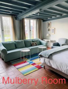 un soggiorno con divano e letto di Kasteelhof van Loppem a Loppem