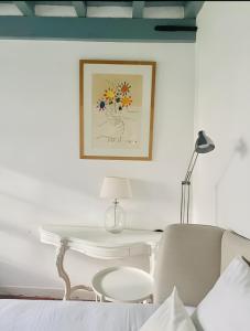 a white table with a lamp and a white chair at Kasteelhof van Loppem in Loppem