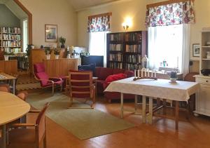 クリスティーネハムンにあるLägenhet Elofstorps Gamla Missionshusのリビングルーム(ソファ、テーブル、椅子付)