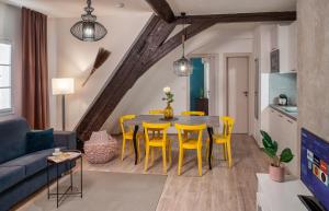 a living room with a dining room table and yellow chairs at 7 Tales Apartments by Adrez in Prague