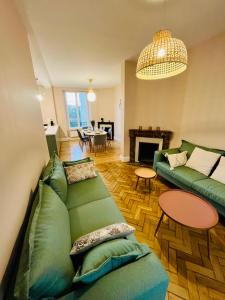 Maison Meulière avec jardin في إيبيرني: غرفة معيشة مع أريكة خضراء وطاولة