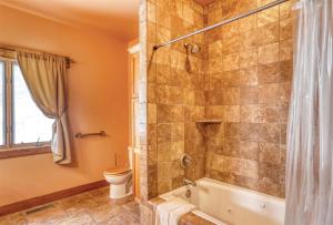 a bathroom with a shower and a toilet at Westwinds Lodge in Lead +24 photos