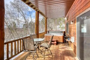 a screened in porch with a hot tub and a table and chairs at Westwinds Lodge in Lead