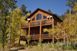 a log home with a wrap around deck at Westwinds Lodge in Lead