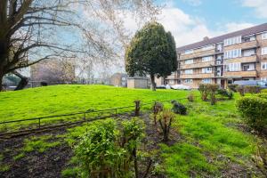a green field with a building in the background at Modern 2 BR Near Brixton Station in London