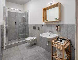 La salle de bains est pourvue d'un lavabo, de toilettes et d'une douche. dans l'établissement 7 Tales Apartments by Adrez, à Prague