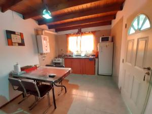 a kitchen with a table and chairs and a refrigerator at Departamentos Luci in Embalse