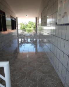 an empty hallway with tables and chairs in a building at Carneiros Camping Hostel in Tamandaré