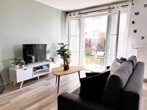 a living room with a couch and a tv at *NEW* ALBA 6 pax Appart 8min Disney in Serris