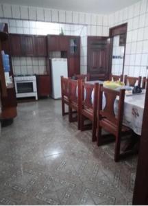 Carneiros Camping Hostel في تامانداري: مطبخ مع طاولة وكراسي وثلاجة