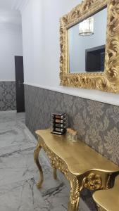 a gold dressing table with a mirror on a wall at Apartament Jaracza 28/7 in Słupsk