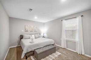 een witte slaapkamer met een bed en een raam bij 3 Bedroom Home The Neighborhood Spot desks in 2 rooms high speed Internet wifi Kick Back & Relax close to Houston Hobby Airport 5 star superhost in Pasadena
