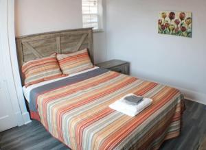 um quarto com uma cama com um cobertor listrado colorido em Massive 4 Bed House-Short Walk to Amazing View em Pittsburgh