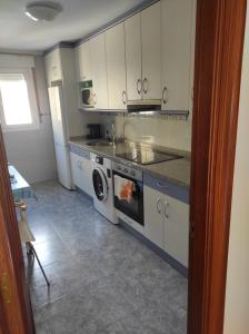uma cozinha com armários brancos e um forno com placa de fogão em Travesía de La Rioja em Casalarreina