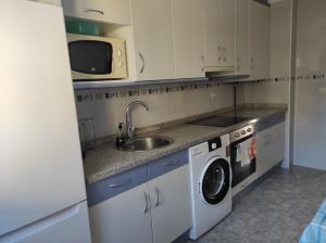 a kitchen with a sink and a washing machine at Travesía de La Rioja in Casalarreina