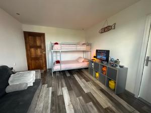 a room with two bunk beds and a desk at La Clé de Taulé in Taulé