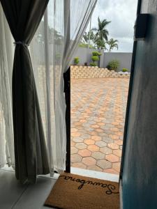 una puerta abierta a un patio con suelo de baldosa en Entindini guest house en Empangeni