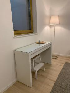 a white desk with a chair and a lamp at FeWo Weiß Mauchen in Schliengen