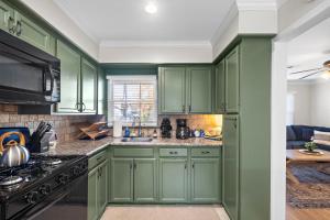 a kitchen with green cabinets and a stove at Kick Back & Relax WiFi Desk Smart TVs Tire swing in Pasadena