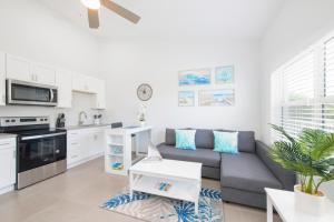 a living room with a couch and a kitchen at Summertime Suites #49 in West Bay