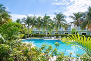 uma piscina em frente a um edifício com palmeiras em Summertime Suites #49 em West Bay